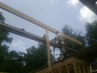 Carpenter setting a ridge beam over a new addition frame — Ice Dam Removal by Roofing Brothers in Rothsay
