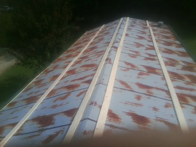 Rusted metal roof panels with new wood purlins before replacement — Storm Damage Roof Repair in Rothsay by Roofing Brothers