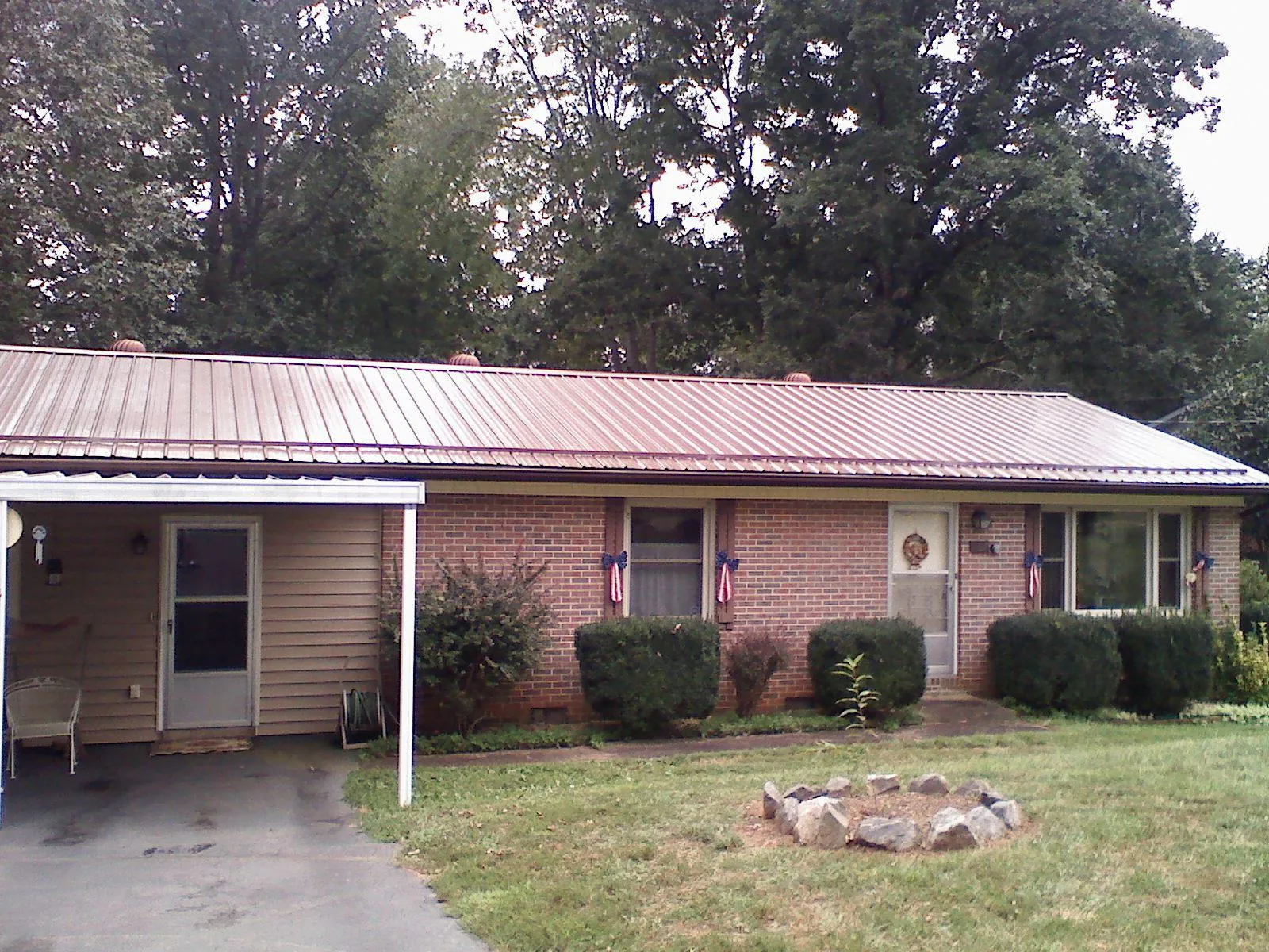 Bronze metal roof and carport on a brick ranch home — Roof Repair work by our crew in Rothsay